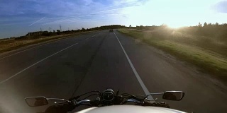 骑车人骑着摩托车在高速公路上行驶，戴着头盔