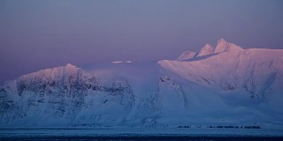 北极山坡上冉冉升起的太阳。在霍恩松德峡湾附近。