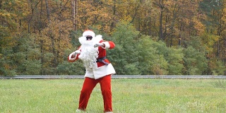 圣诞老人在草地上跳舞。背景是森林。50帧/秒