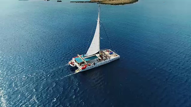 在塞浦路斯阿伊纳帕的地中海上驾驶双体船。空中无人机拍摄。