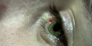 特写的绿色女性眼睛眨眼和虹膜聚焦。UHD股票视频