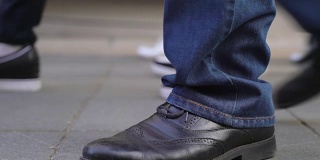 概念人群脚与鞋的特写。无名的人走在街上。在上下班途中无法辨认的人群。低角度的观点。鞋子是反映人性格特征的镜子