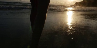 一个女人在巴西的海滩上走日落