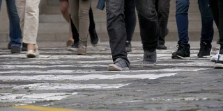 在人行横道上慢动作行走的人群的脚
