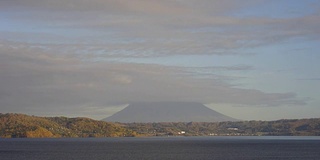 移动云延时:从洞屋湖，北海道，日本。Yotei山在云的后面。