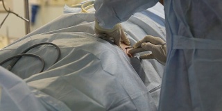 外科医生先开一个小口开始手术。