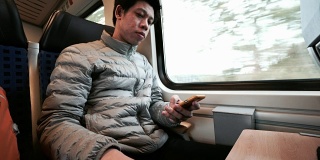 男人在火车上用智能手机