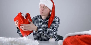 年轻人戴着圣诞老人的帽子看着圣诞老人的裤子50帧/秒
