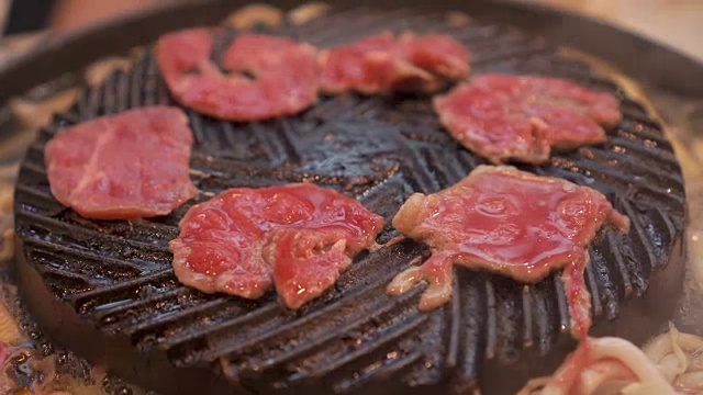 烹饪烧烤，在炉子上的木炭上烤。关闭牛肉烤在日本餐厅。用于烧烤或日式食物的生牛肉片