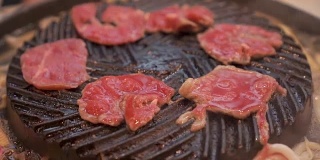 烹饪烧烤，在炉子上的木炭上烤。关闭牛肉烤在日本餐厅。用于烧烤或日式食物的生牛肉片
