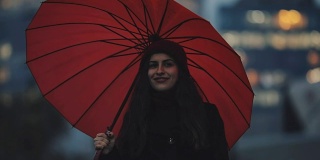 红伞下的快乐女人在市中心散步