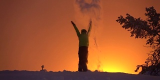 慢镜头:向天空抛雪，向金色的夕阳骄傲地举起双臂
