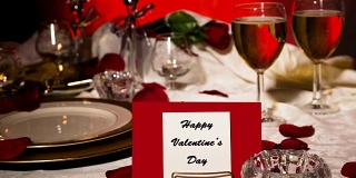情人节餐厅。浪漫的餐桌布置。卡、餐盘。礼物。