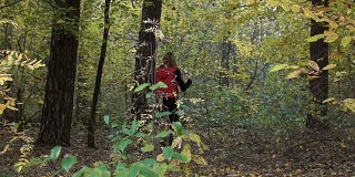 一个女人和一个男人在树林里玩追赶游戏。他们大笑，胡闹。