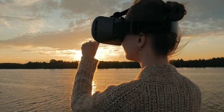 日落时分，一名女子在游轮甲板上戴着虚拟现实眼镜