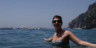 在意大利阿马尔菲海岸波西塔诺的海里放松的女人