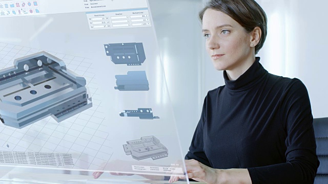 在不久的将来美丽的女工程师工作在她的电脑透明显示。她构建了复杂的三维模型。办公室是明亮和现代的。