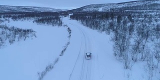 空中汽车在雪道上行驶，穿过令人惊叹的山区冬季景观