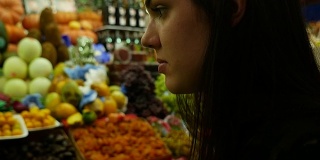 在公共市场上吃异国水果的女人