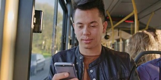 一个年轻人在公交车上用智能手机