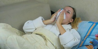 慢镜头:穿着睡衣的小女孩躺在沙发上咳嗽、打喷嚏。