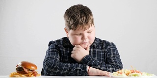年轻的胖男孩选择健康和不健康的食物50帧/秒