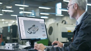 总工程师使用个人计算机，CAD设计机械零件。他在大工厂工作。视频素材模板下载