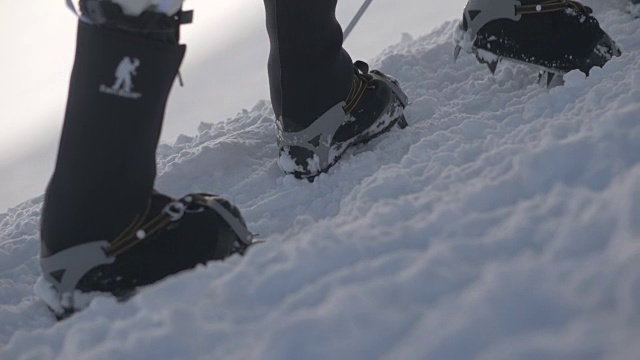 游客在冰爪行走在雪道在山近距离