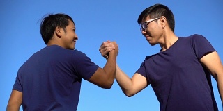 两名亚洲男子用摔跤的方式握手