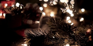 圣诞礼盒装饰在圣诞帽与树和散焦灯