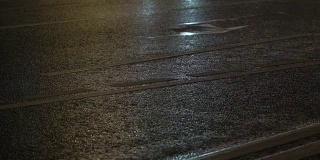 夜城开车灯。雨后潮湿的路面上反射的汽车前灯模糊不清