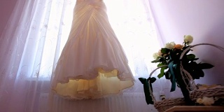 结婚的那一天。新娘的礼服挂在窗户上