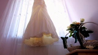 结婚的那一天。新娘的礼服挂在窗户上视频素材模板下载