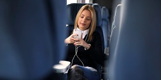 年轻女子在火车上听音乐