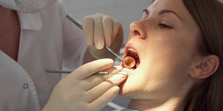 牙科医生在诊所为女病人治疗牙齿。工作中的女专业医生。牙科检查
