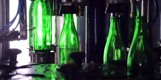 流水生产线。绿色玻璃瓶沿着生产线自动移动，并装满水