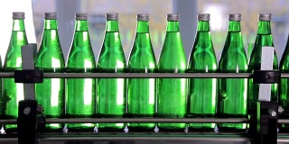 绿色矿泉水瓶沿着自动生产线移动。