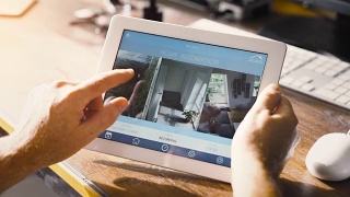 男人在智能设备上使用智能家居应用程序。智能房子自动化视频素材模板下载