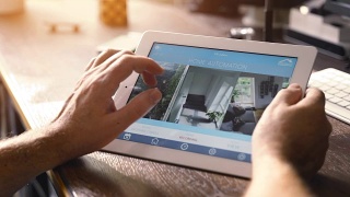 男人在智能设备上使用智能家居应用程序。智能房子自动化视频素材模板下载