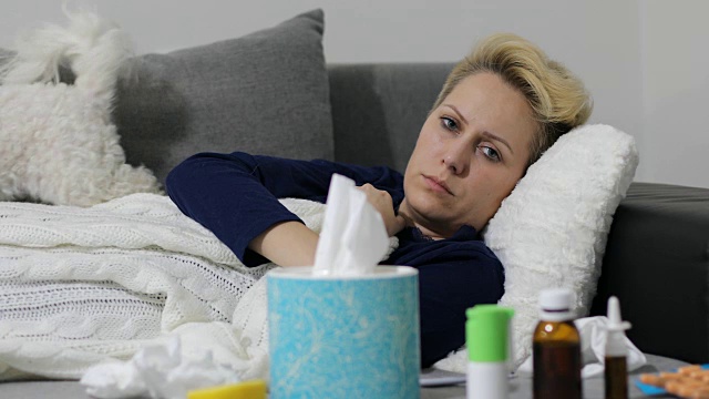 生病的女人感冒了女人感冒了打喷嚏到组织中。头疼病毒