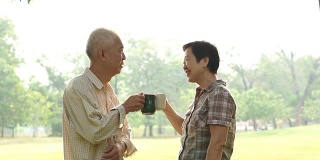 亚洲老夫妇在公园喝咖啡庆祝生活
