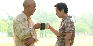 亚洲老夫妇在公园喝咖啡庆祝生活