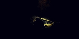 人类用手电筒探索黑暗的洞穴