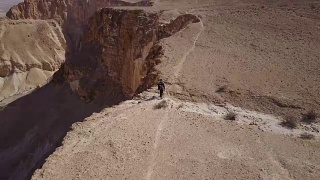 徒步旅行者在沙漠中爬山的鸟瞰图视频素材模板下载