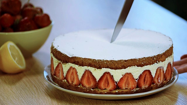 用刀切一片草莓蛋糕