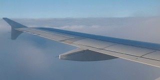 一架小型客机的机翼，在稠密的云层和乱流区域