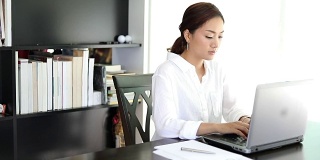 亚洲商务女性使用笔记本在办公室工作