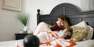 一个在床上用纸巾擤鼻子的女人