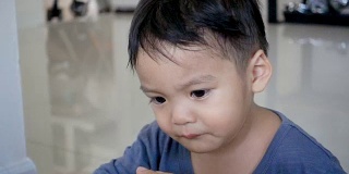 2岁亚洲男婴在室内哭泣。