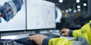 在重工业工厂里面，工业工程师的手在个人电脑上工作的特写镜头设计涡轮/发动机在3D，使用CAD程序。